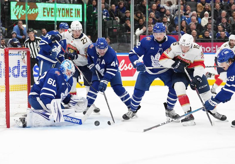 Nov 28, 2023; Toronto, Ontario, CAN; Florida Panthers center Eetu Luostarinen (27) battles for the puck with Toronto Maple Leafs defenseman Morgan Rielly (44) during the second period at Scotiabank Arena. Mandatory Credit: Nick Turchiaro-USA TODAY Sports