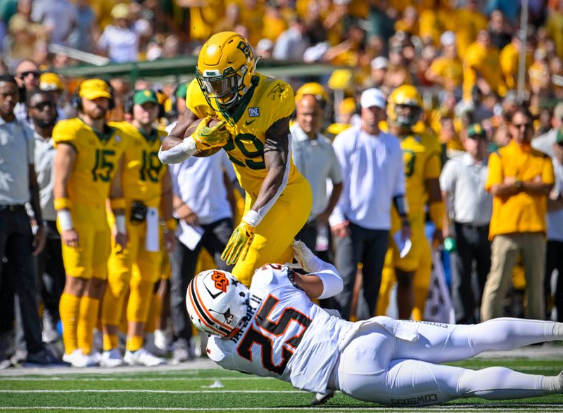 Oct 1, 2022; Waco, Texas, USA; Baylor Bears running back Richard Reese (29) is tackled by Oklahoma State Cowboys safety Jason Taylor II (25) during the second quarter at McLane Stadium. Mandatory Credit: Jerome Miron-USA TODAY Sports