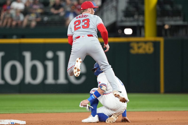 Sep 7, 2024; Arlington, Texas, USA; Los Angeles Angels second baseman Brandon Drury (23) leaps after forcing out Texas Rangers third baseman Josh Jung (6) during the sixth inning at Globe Life Field. Mandatory Credit: Jim Cowsert-Imagn Images