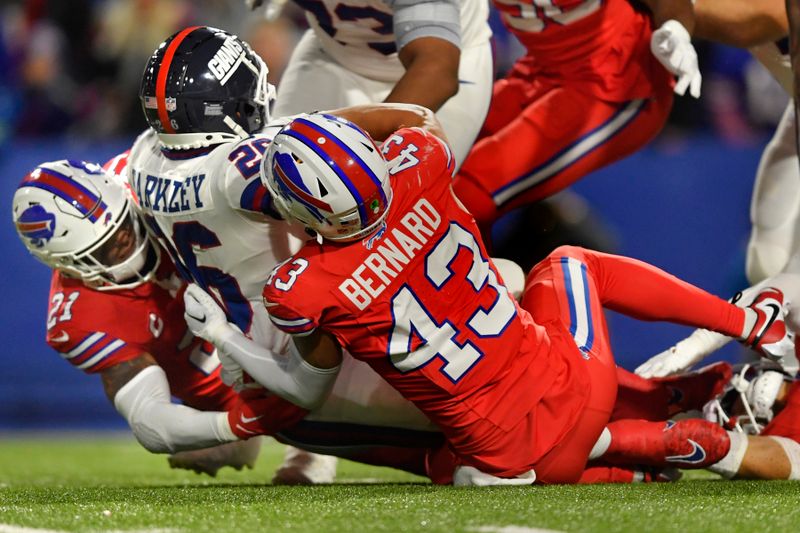 Buffalo Bills linebacker Terrel Bernard (43) and safety Jordan Poyer (take down New York Giants running back Saquon Barkley, center, during the first half of an NFL football game in Orchard Park, N.Y., Sunday, Oct. 15, 2023. (AP Photo/Adrian Kraus)