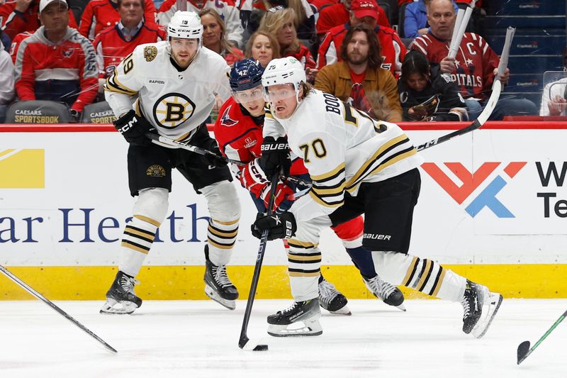 Apr 15, 2024; Washington, District of Columbia, USA; Boston Bruins center Jesper Boqvist (70) skates with the puck as Washington Capitals defenseman Martin Fehervary (42) chases in the second period at Capital One Arena. Mandatory Credit: Geoff Burke-USA TODAY Sports