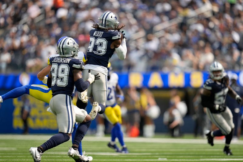 Dallas Cowboys safety Julius Wood (33) intercepts a pass as safety Emany Johnson (39) looks on in the second half of a preseason NFL football game against the Los Angeles Rams, Sunday, Aug. 11, 2024, in Inglewood, Calif. (AP Photo/Gregory Bull)