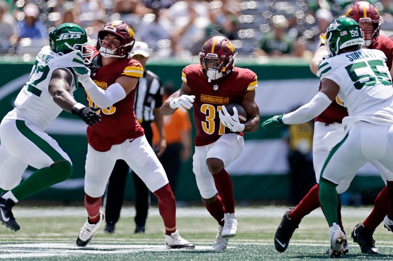 Washington Commanders running back Jeremy McNichols (31) rushes with the football during a pre-season NFL football game against the New York Jets Saturday, Aug. 10, 2024, in East Rutherford, N.J. (AP Photo/Adam Hunger)