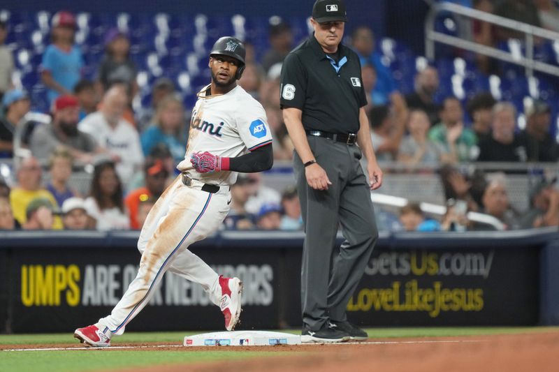 Jul 23, 2024; Miami, Florida, USA;  Miami Marlins second baseman Otto Lopez (61) takes third base after a throwing error on his attempt to steal second base in the second inning against the Baltimore Orioles at loanDepot Park. Mandatory Credit: Jim Rassol-USA TODAY Sports