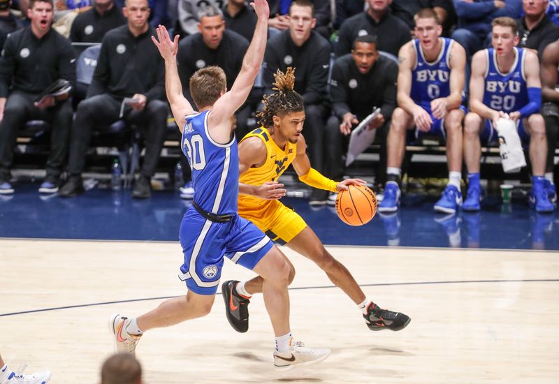 Feb 3, 2024; Morgantown, West Virginia, USA; West Virginia Mountaineers guard Noah Farrakhan (1) drives against Brigham Young Cougars guard Dallin Hall (30) during the first half at WVU Coliseum. Mandatory Credit: Ben Queen-USA TODAY Sports