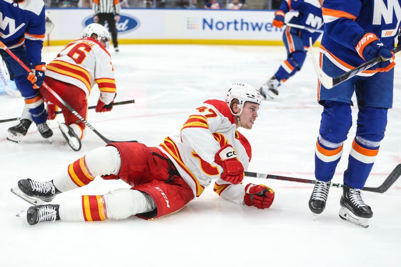 Feb 10, 2024; Elmont, New York, USA;  Calgary Flames center Connor Zary (47) falls on to the ice after a collision in the third period New York Islanders at UBS Arena. Mandatory Credit: Wendell Cruz-USA TODAY Sports