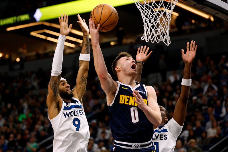 MINNEAPOLIS, MINNESOTA - NOVEMBER 01: Christian Braun #0 of the Denver Nuggets goes up for a shot past Nickeil Alexander-Walker #9 of the Minnesota Timberwolves in the third quarter at Target Center on November 01, 2023 in Minneapolis, Minnesota. The Timberwolves defeated the Nuggets 110-89. NOTE TO USER: User expressly acknowledges and agrees that, by downloading and or using this photograph, User is consenting to the terms and conditions of the Getty Images License Agreement. (Photo by David Berding/Getty Images)