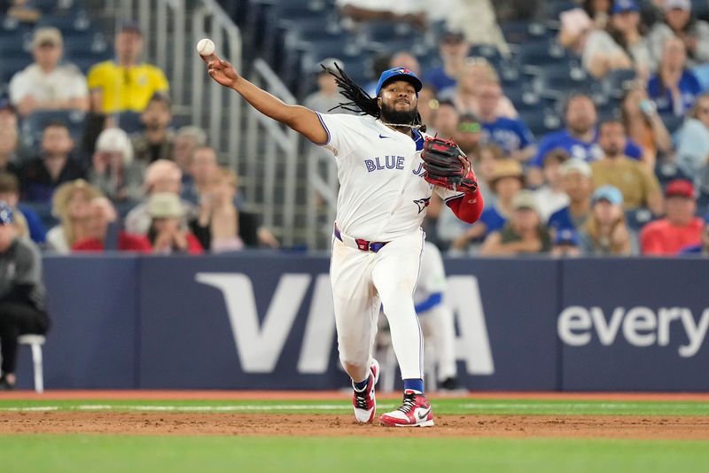 Jun 4, 2024; Toronto, Ontario, CAN; Toronto Blue Jays third baseman Vladimir Guerrero Jr. (27) throws to first base to get out Baltimore Orioles left fielder Austin Hays (not pictured) during the eighth inning at Rogers Centre. Mandatory Credit: John E. Sokolowski-USA TODAY Sports