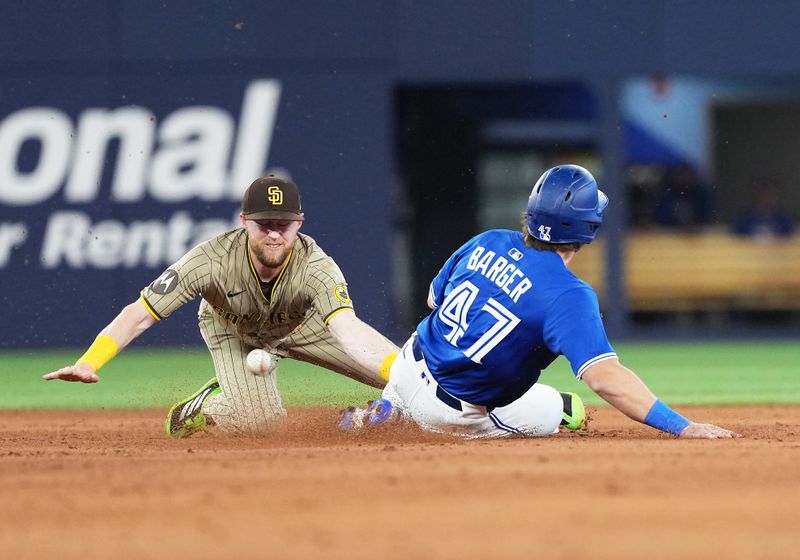 May 20, 2025; Toronto, Ontario, CAN; Toronto Blue Jays third baseman Addison Barger (47) steals second base ahead of the tag from San Diego Padres second base Jake Cronenworth (9) during the fifth inning at Rogers Centre. Mandatory Credit: Nick Turchiaro-Imagn Images