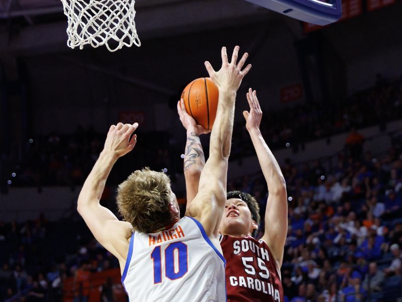 Feb 17, 2026; Gainesville, Florida, USA; South Carolina Gamecocks guard Mike Sharavjamts (55) shoots the ball over Florida Gators forward Thomas Haugh (10) during the first half at Exactech Arena at the Stephen C. O'Connell Center. Mandatory Credit: Matt Pendleton-Imagn Images