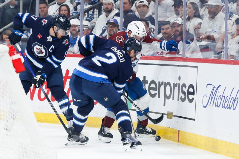 Apr 23, 2024; Winnipeg, Manitoba, CAN; Winnipeg Jets defenseman Neal Pionk (4) and Colorado Avalanche forward Zach Parise (9) battle for the puck during the first period in game two of the first round of the 2024 Stanley Cup Playoffs at Canada Life Centre. Mandatory Credit: Terrence Lee-USA TODAY Sports