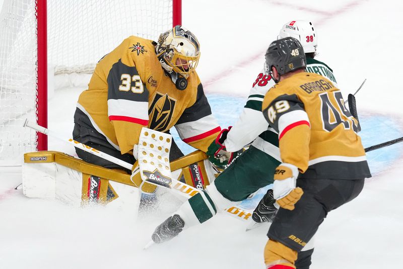 Apr 29, 2025; Las Vegas, Nevada, USA; Vegas Golden Knights goaltender Adin Hill (33) makes a save against Minnesota Wild right wing Ryan Hartman (38) during the third period of game five of the first round of the 2025 Stanley Cup Playoffs at T-Mobile Arena. Mandatory Credit: Stephen R. Sylvanie-Imagn Images