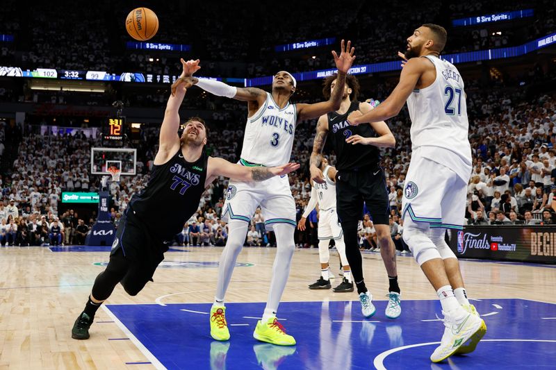 MINNEAPOLIS, MINNESOTA - MAY 24: Luka Doncic #77 of the Dallas Mavericks is fouled by Jaden McDaniels #3 of the Minnesota Timberwolves during the fourth quarter in Game Two of the Western Conference Finals at Target Center on May 24, 2024 in Minneapolis, Minnesota. NOTE TO USER: User expressly acknowledges and agrees that, by downloading and or using this photograph, User is consenting to the terms and conditions of the Getty Images License Agreement. (Photo by David Berding/Getty Images)