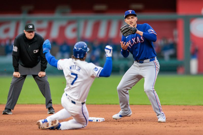 May 4, 2024; Kansas City, Missouri, USA; Texas Rangers shortstop Corey Seager (5) looks to throw to first base as Kansas City Royals shortstop Bobby Witt Jr. (7) slides into second base during the fourth inning at Kauffman Stadium. Mandatory Credit: William Purnell-USA TODAY Sports