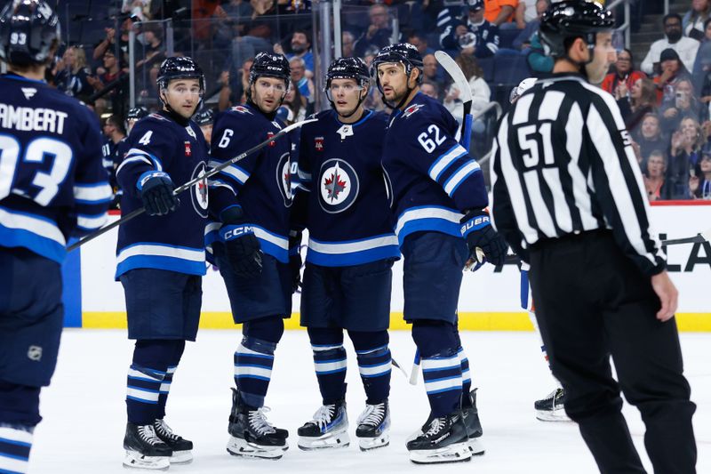 Sep 25, 2024; Winnipeg, Manitoba, CAN; Winnipeg Jets defenseman Colin Miller (6) is congratulated by his teammates on his goal against the Edmonton Oilers during the second period at Canada Life Centre. Mandatory Credit: Terrence Lee-Imagn Images