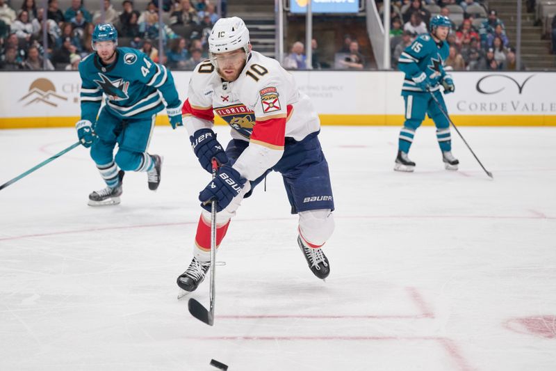 Jan 25, 2025; San Jose, California, USA; Florida Panthers left wing A.J. Greer (10) plays the puck against San Jose Sharks defenseman Marc-Edouard Vlasic (44) during the third period at SAP Center at San Jose. Mandatory Credit: Robert Edwards-Imagn Images