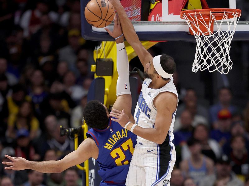 DENVER, COLORADO - JANUARY 05: Jamal Murray #27 of the Denver Nuggets is blocked going to the basket by Jalen Suggs #4 of the Orlando Magic in the first quarter at Ball Arena on January 05, 2024 in Denver, Colorado.  NOTE TO USER: User expressly acknowledges and agrees that, by downloading and or using this photograph, User is consenting to the terms and conditions of the Getty Images License Agreement.  (Photo by Matthew Stockman/Getty Images)