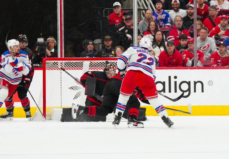 Nov 27, 2024; Raleigh, North Carolina, USA;  New York Rangers center Jonny Brodzinski (22) scores a goal past Carolina Hurricanes goaltender Spencer Martin (41) during the first period at Lenovo Center. Mandatory Credit: James Guillory-Imagn Images