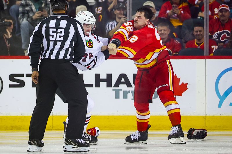 Nov 7, 2025; Calgary, Alberta, CAN; Calgary Flames defenseman MacKenzie Weegar (52) and Chicago Blackhawks defenseman Alex Vlasic (72) fight during the second period at Scotiabank Saddledome. Mandatory Credit: Sergei Belski-Imagn Images