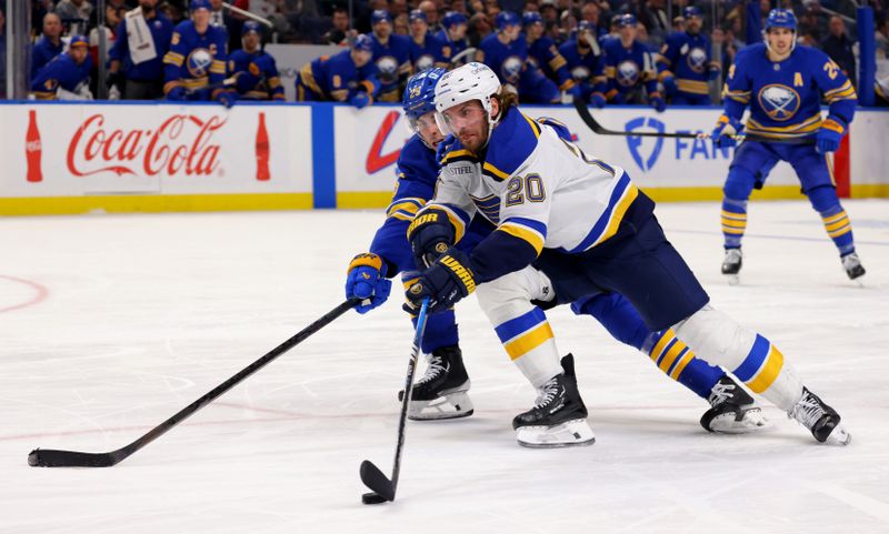 Nov 14, 2024; Buffalo, New York, USA;  St. Louis Blues left wing Brandon Saad (20) skates to the net with the puck as Buffalo Sabres defenseman Owen Power (25) defends during the third period at KeyBank Center. Mandatory Credit: Timothy T. Ludwig-Imagn Images