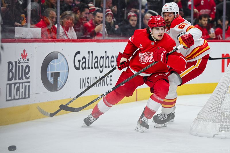 Nov 27, 2024; Detroit, Michigan, USA; Detroit Red Wings center Marco Kasper (92) and Calgary Flames defenseman Daniil Miromanov (62) battle for the puck during the second period at Little Caesars Arena. Mandatory Credit: Tim Fuller-Imagn Images