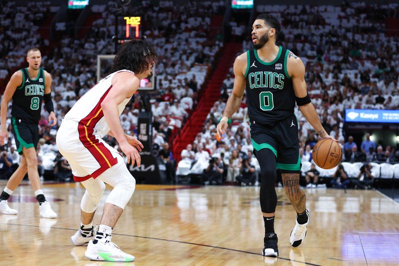 MIAMI, FLORIDA - APRIL 27: Jayson Tatum #0 of the Boston Celtics dribbles the ball against Jaime Jaquez Jr. #11 of the Miami Heat during the first quarter in game three of the Eastern Conference First Round Playoffs at Kaseya Center on April 27, 2024 in Miami, Florida.  NOTE TO USER: User expressly acknowledges and agrees that, by downloading and or using this photograph, User is consenting to the terms and conditions of the Getty Images License Agreement. (Photo by Megan Briggs/Getty Images)