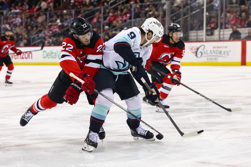 Dec 6, 2024; Newark, New Jersey, USA; Seattle Kraken center Chandler Stephenson (9) skates with the puck while being defended by New Jersey Devils defenseman Brett Pesce (22) during the first period at Prudential Center. Mandatory Credit: Ed Mulholland-Imagn Images