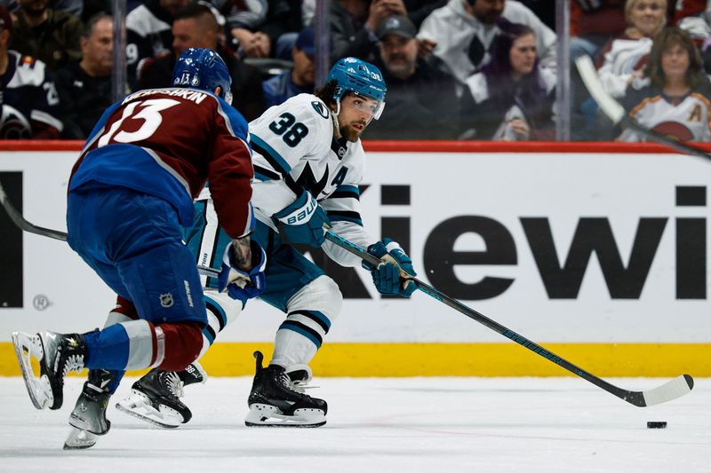 Mar 6, 2025; Denver, Colorado, USA; San Jose Sharks defenseman Mario Ferraro (38) controls the puck under pressure from Colorado Avalanche right wing Valeri Nichushkin (13) in the first period at Ball Arena. Mandatory Credit: Isaiah J. Downing-Imagn Images