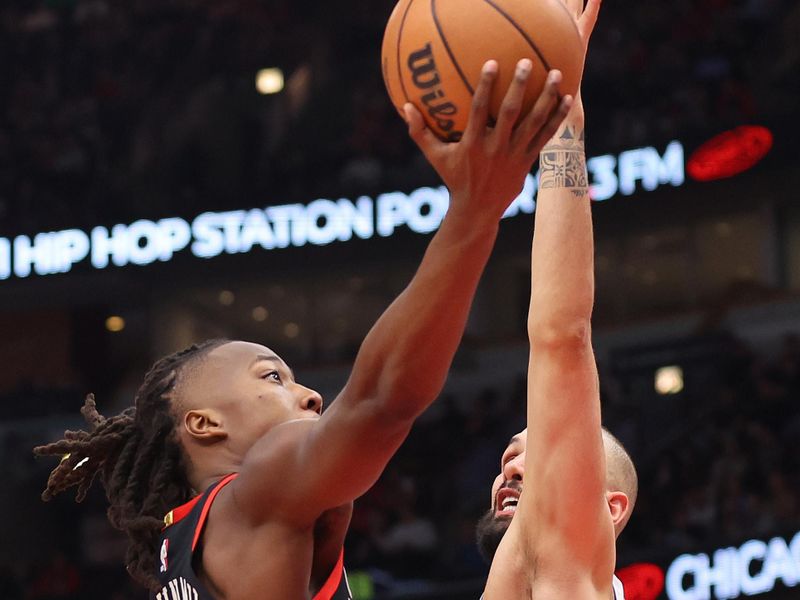 CHICAGO, ILLINOIS - FEBRUARY 27: Ayo Dosunmu #12 of the Chicago Bulls goes up for a layup against Evan Fournier #31 of the Detroit Pistons during the first half at the United Center on February 27, 2024 in Chicago, Illinois. NOTE TO USER: User expressly acknowledges and agrees that, by downloading and or using this photograph, User is consenting to the terms and conditions of the Getty Images License Agreement. (Photo by Michael Reaves/Getty Images)