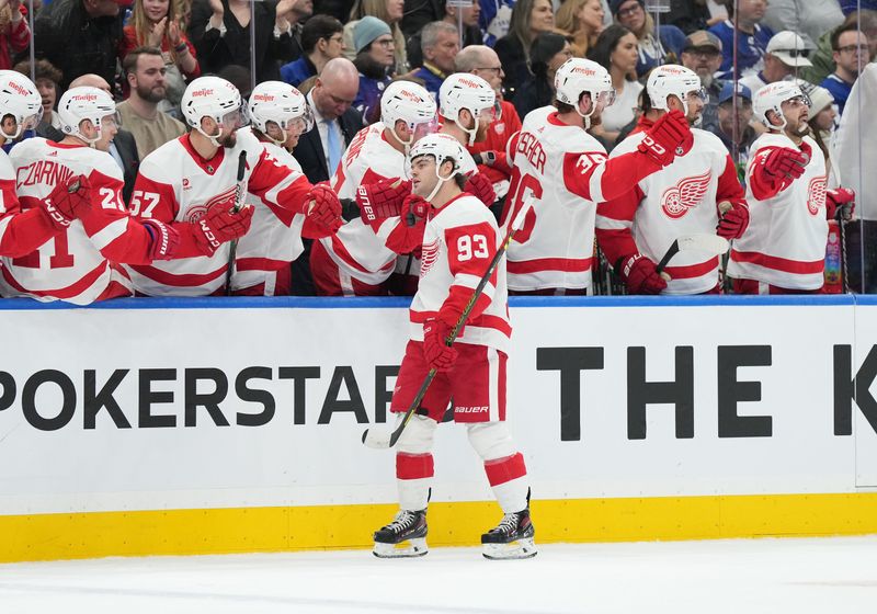 Apr 13, 2024; Toronto, Ontario, CAN; Detroit Red Wings right wing Alex DeBrincat (93) celebrates at the bench after scoring goal  against the Toronto Maple Leafs during the first period at Scotiabank Arena. Mandatory Credit: Nick Turchiaro-USA TODAY Sports