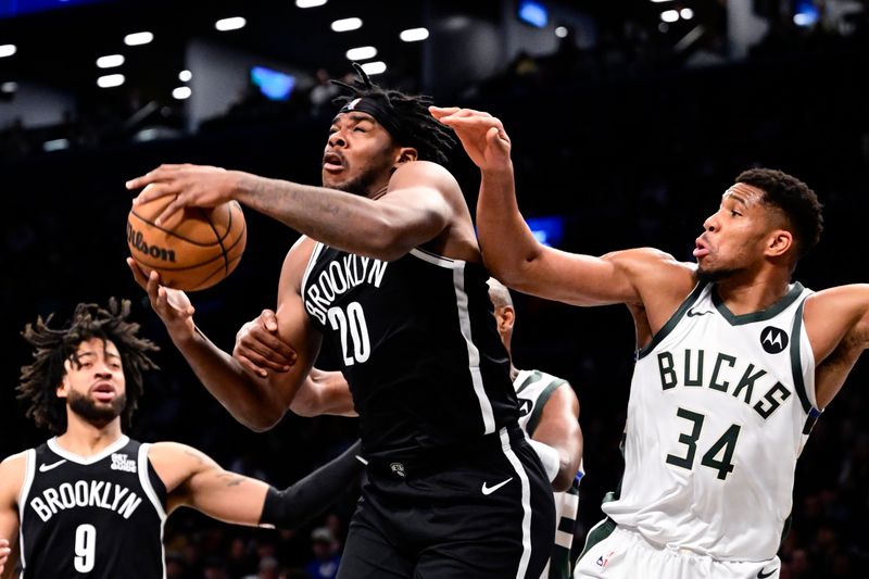 NEW YORK, NEW YORK - DECEMBER 08: Day'Ron Sharpe #20 of the Brooklyn Nets is defended by Giannis Antetokounmpo #34 of the Milwaukee Bucks during the second half at Barclays Center on December 08, 2024 in New York City. NOTE TO USER: User expressly acknowledges and agrees that, by downloading and or using this Photograph, user is consenting to the terms and conditions of the Getty Images License Agreement. (Photo by Steven Ryan/Getty Images)