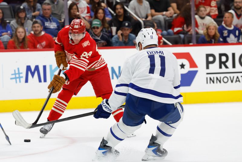 Oct 11, 2025; Detroit, Michigan, USA;  Detroit Red Wings right wing Patrick Kane (88) skates with the puck defended by Toronto Maple Leafs center Max Domi (11) in the second period at Little Caesars Arena. Mandatory Credit: Rick Osentoski-Imagn Images