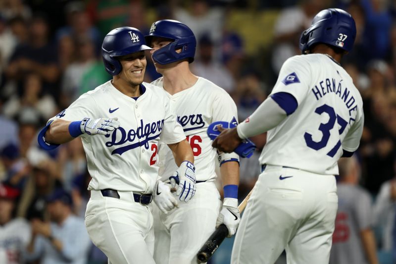 Sep 11, 2024; Los Angeles, California, USA;  Los Angeles Dodgers center fielder Tommy Edman (25) celebrates with catcher Will Smith (16) and left fielder Teoscar Hernandez (37) after hitting a 2-run home run during the eighth inning against the Chicago Cubs at Dodger Stadium. Mandatory Credit: Kiyoshi Mio-Imagn Images