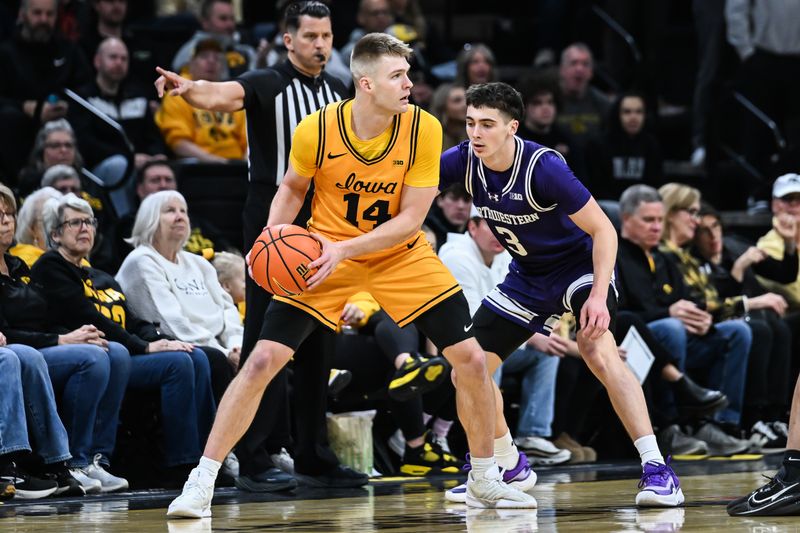Feb 8, 2026; Iowa City, Iowa, USA; Iowa Hawkeyes guard Bennett Stirtz (14) controls the ball as Northwestern Wildcats guard Jake West (3) defends during the first half at Carver-Hawkeye Arena. Mandatory Credit: Jeffrey Becker-Imagn Images