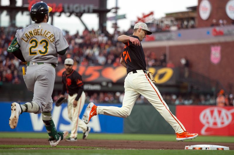 May 17, 2025; San Francisco, California, USA; San Francisco Giants pitcher Tyler Rogers (71) beats Athletics catcher Shea Langeliers (23) to first base on a ground ball during the eighth inning at Oracle Park. Mandatory Credit: D. Ross Cameron-Imagn Images
