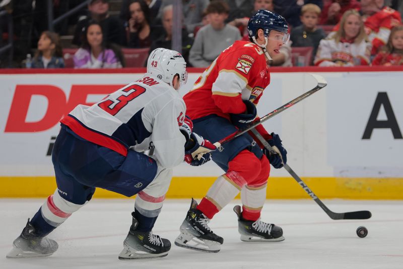 Nov 25, 2024; Sunrise, Florida, USA; Florida Panthers center Carter Verhaeghe (23) moves the puck past Washington Capitals right wing Tom Wilson (43) during the second period at Amerant Bank Arena. Mandatory Credit: Sam Navarro-Imagn Images
