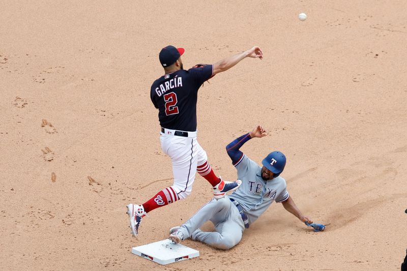 Jul 9, 2023; Washington, District of Columbia, USA; Washington Nationals second baseman Luis Garcia (2) attempts to turn a double play at second base ahead of a slide by Texas Rangers second baseman Marcus Semien (2) on a ground ball by Rangers shortstop Corey Seager (not pictured) during the eighth inning at Nationals Park. Mandatory Credit: Geoff Burke-USA TODAY Sports