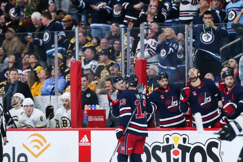 Dec 22, 2023; Winnipeg, Manitoba, CAN;  Winnipeg Jets forward Gabriel Vilardi (13) is congratulated by his team mates on his goal against the Boston Bruins during the second period at Canada Life Centre. Mandatory Credit: Terrence Lee-USA TODAY Sports