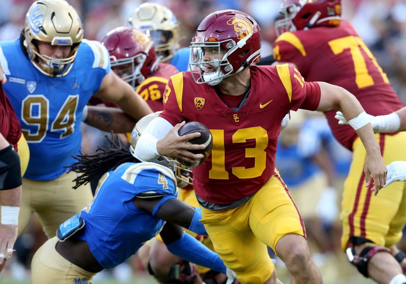 Nov 18, 2023; Los Angeles, California, USA; USC Trojans quarterback Caleb Williams (13) scrambles against UCLA Bruins defensive lineman Carl Jones Jr. (4) during the second quarter at United Airlines Field at Los Angeles Memorial Coliseum. Mandatory Credit: Jason Parkhurst-USA TODAY Sports