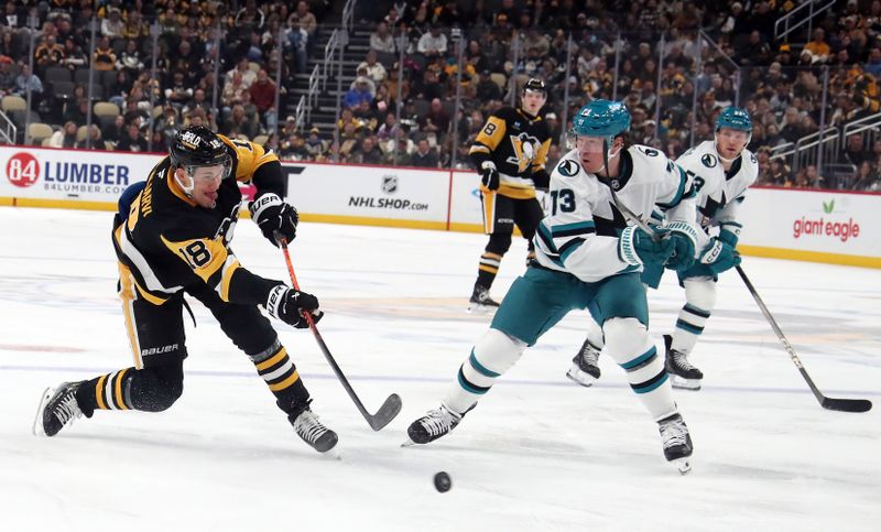 Nov 16, 2024; Pittsburgh, Pennsylvania, USA;  Pittsburgh Penguins right wing Jesse Puljujarvi (18) shots the puck against San Jose Sharks center Tyler Toffoli (73) during the third period at PPG Paints Arena. Mandatory Credit: Charles LeClaire-Imagn Images