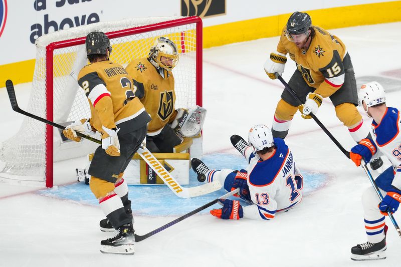 May 6, 2025; Las Vegas, Nevada, USA; Vegas Golden Knights goaltender Adin Hill (33) makes a save after the puck deflects off a fallen Edmonton Oilers center Mattias Janmark (13) during the third period of game one of the second round of the 2025 Stanley Cup Playoffs at T-Mobile Arena. Mandatory Credit: Stephen R. Sylvanie-Imagn Images