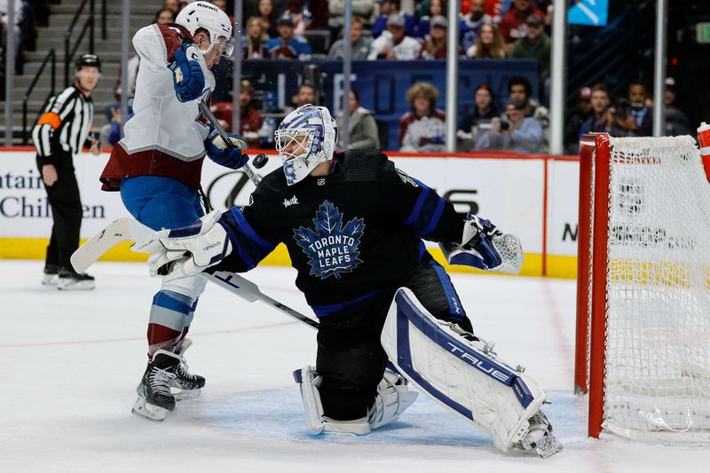 Feb 24, 2024; Denver, Colorado, USA; Toronto Maple Leafs goaltender Ilya Samsonov (35) deflects a shot as Colorado Avalanche center Ross Colton (20) reacts in the second period at Ball Arena. Mandatory Credit: Isaiah J. Downing-USA TODAY Sports