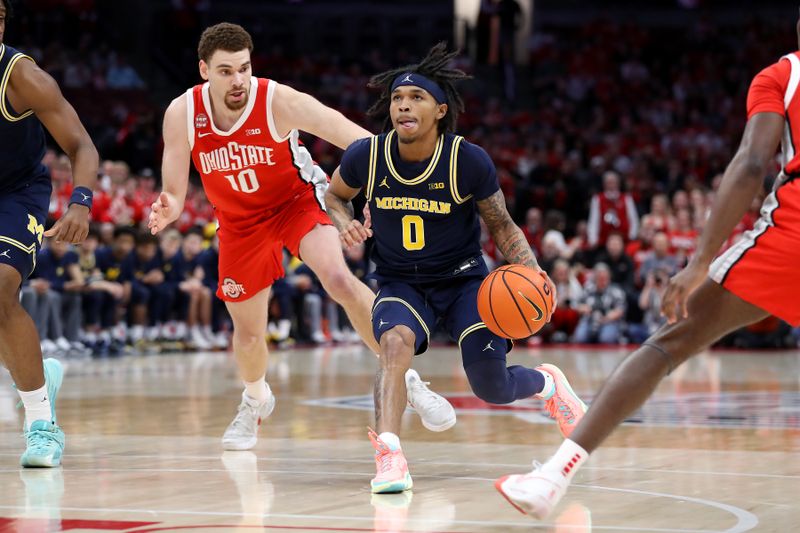 Mar 3, 2024; Columbus, Ohio, USA; Michigan Wolverines guard Dug McDaniel (0) dribbles the ball as Ohio State Buckeyes forward Jamison Battle (10) defends during the first half at Value City Arena. Mandatory Credit: Joseph Maiorana-USA TODAY Sports