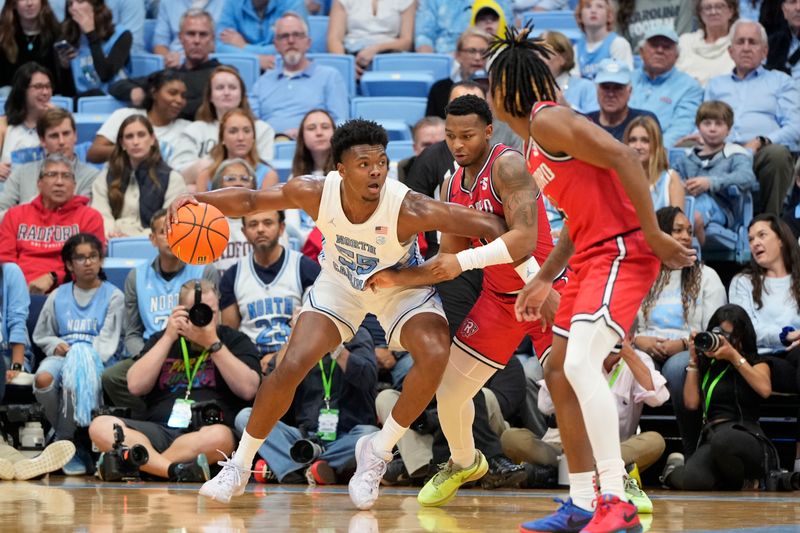 Nov 6, 2023; Chapel Hill, North Carolina, USA; North Carolina Tar Heels forward Harrison Ingram (55) with the ball as Radford Highlanders guard DaQuan Smith (1) defends in the first half at Dean E. Smith Center. Mandatory Credit: Bob Donnan-USA TODAY Sports