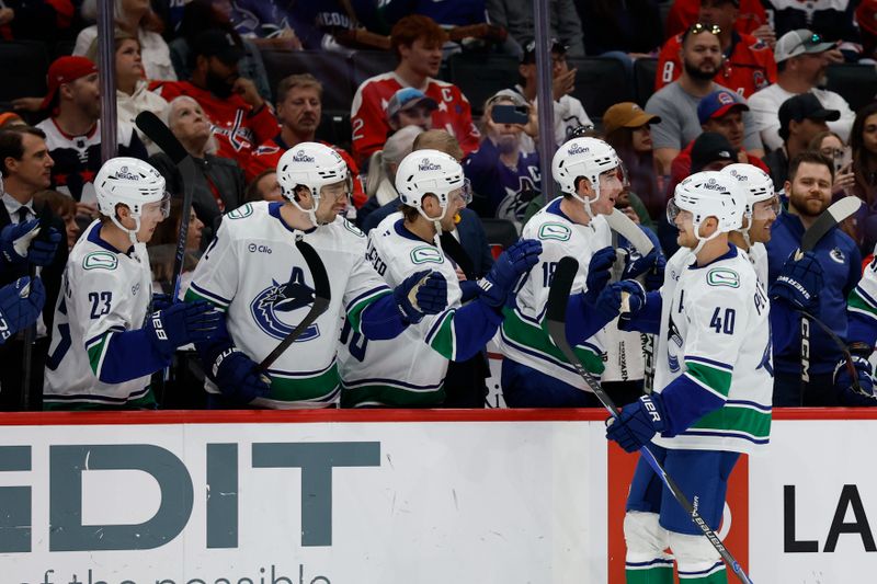 Oct 19, 2025; Washington, District of Columbia, USA; Vancouver Canucks center Elias Pettersson (40) celebrates with teammates after scoring a goal against the Washington Capitals during the first period at Capital One Arena. Mandatory Credit: Geoff Burke-Imagn Images