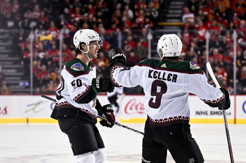 Jan 16, 2024; Calgary, Alberta, CAN; Arizona Coyotes defenseman Sean Durzi (50) celebrates after scoring a goal against the Calgary Flames with right wing Clayton Keller (9) during the second period at Scotiabank Saddledome. Mandatory Credit: Brett Holmes-USA TODAY Sports