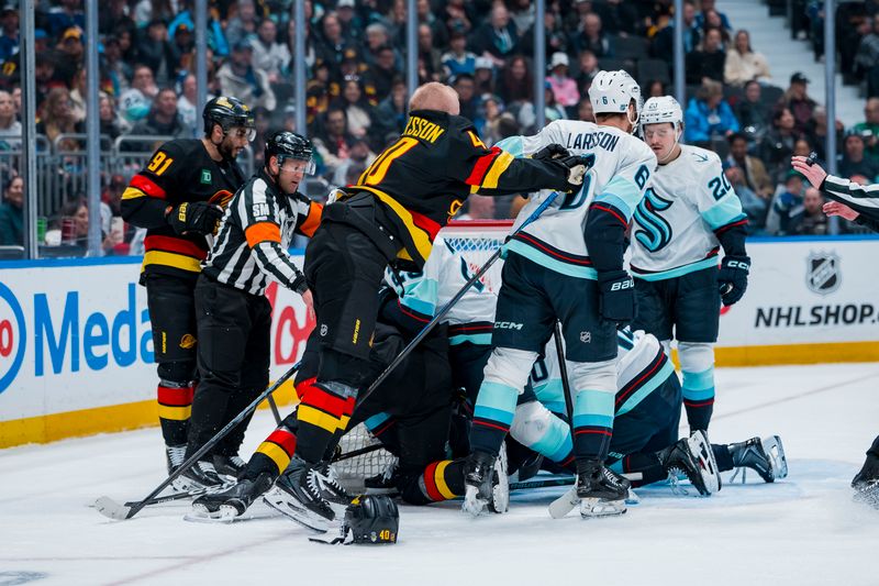 Mar 14, 2026; Vancouver, British Columbia, CAN;  Vancouver Canucks forward Elias Pettersson (40) pushes Seattle Kraken defenseman Adam Larsson (6) during a stop in play in the second period at Rogers Arena. Mandatory Credit: Bob Frid-Imagn Images