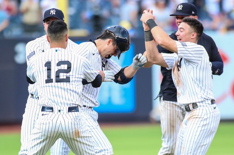 Sep 10, 2023; Bronx, New York, USA;  New York Yankees catcher Kyle Higashioka (66) is mobbed by teammates after hitting a game winning RBI double in the thirteenth inning against the Milwaukee Brewers at Yankee Stadium. Mandatory Credit: Wendell Cruz-USA TODAY Sports