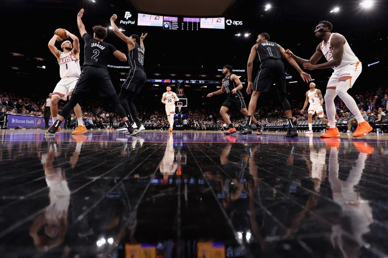 PHOENIX, ARIZONA - DECEMBER 13: Devin Booker #1 of the Phoenix Suns looks to shoot under pressure from Cameron Johnson #2 and Nic Claxton #33 of the Brooklyn Nets during the second half of the NBA game at Footprint Center on December 13, 2023 in Phoenix, Arizona. The Nets defeated the Suns 116-112. NOTE TO USER: User expressly acknowledges and agrees that, by downloading and or using this photograph, User is consenting to the terms and conditions of the Getty Images License Agreement.  (Photo by Christian Petersen/Getty Images)