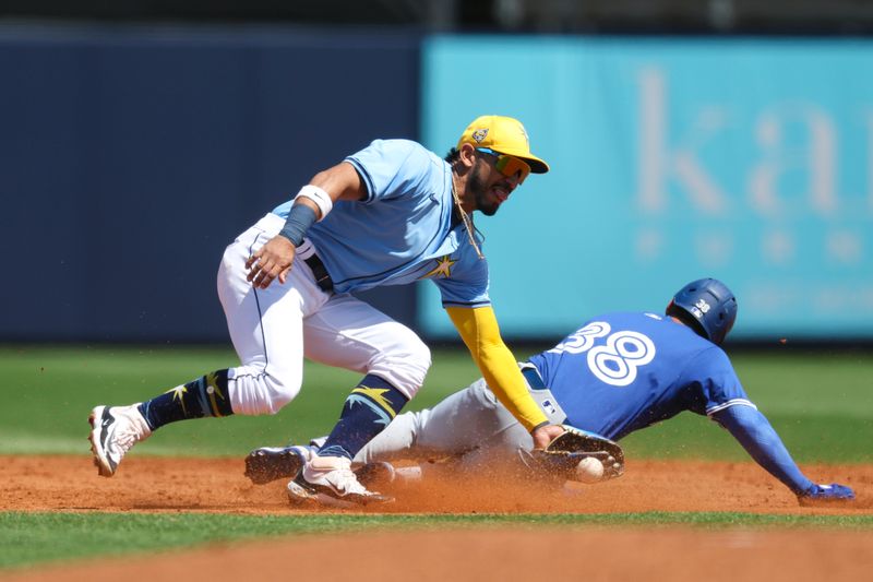 Mar 11, 2024; Port Charlotte, Florida, USA;  Toronto Blue Jays right fielder Nathan Lukes (38) steps second base from Tampa Bay Rays shortstop Jose Caballero (7) in the third inning at Charlotte Sports Park. Mandatory Credit: Nathan Ray Seebeck-USA TODAY Sports